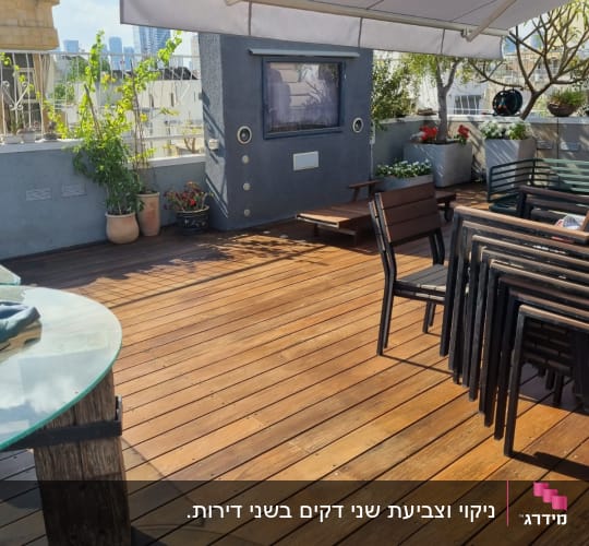 רצפת עץ עם שולחן וכיסאות בגינה